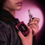 Model holding the YSL Black Opium Pink Glaze bottle